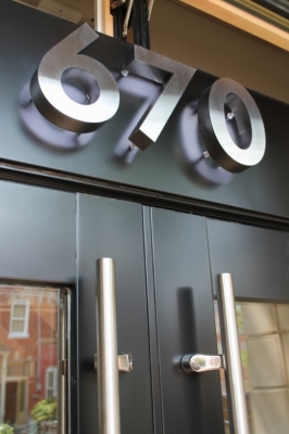 Brushed fabricated stainless steel numbers LED illuminated from behind.