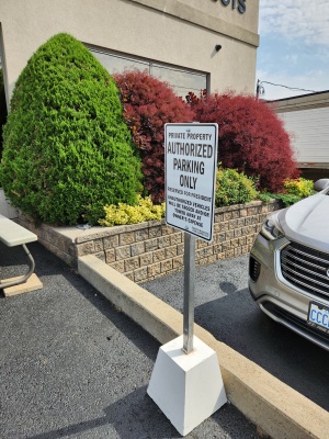Custom-aluminum-parking-sign-on-a-post-with-concrete-base