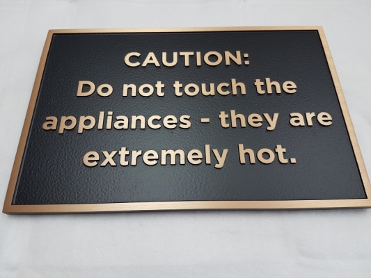 Custom bronze plaque with raised text Caution