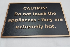 Custom bronze plaque with raised text Caution